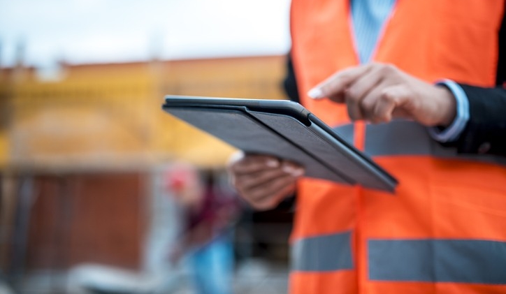 Two architects are using digital tablet on construction site.